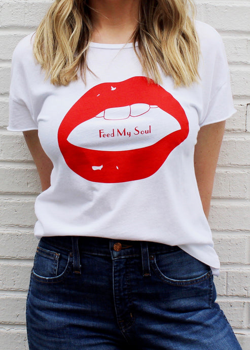 Female modeling white relaxed graphic tee with red lips that reads Feed My Soul.